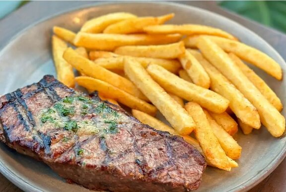 A steak on a plate with chips