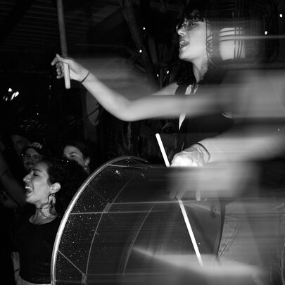 A blurred motion, black and white image of people dancing and enjoying a performance. 