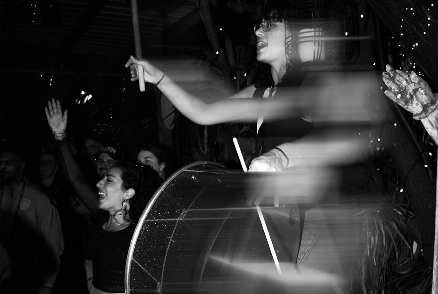 A blurred motion, black and white image of people dancing and enjoying a performance. 