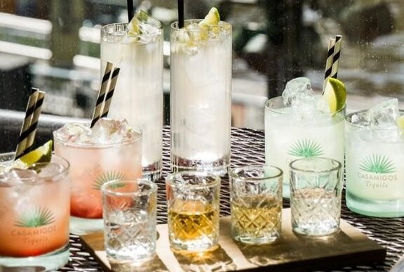 A selection of cocktails in different sized glasses arranged on a table.