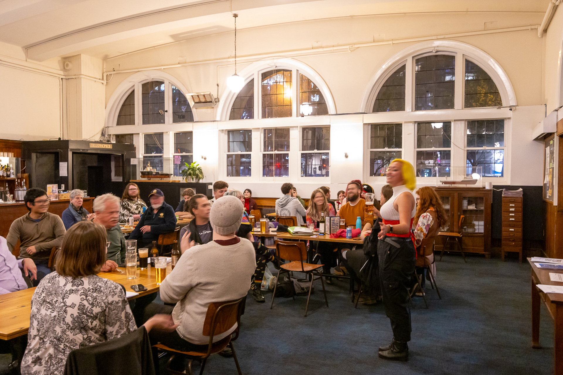 A group of people are singing sea shanties inside an old building
