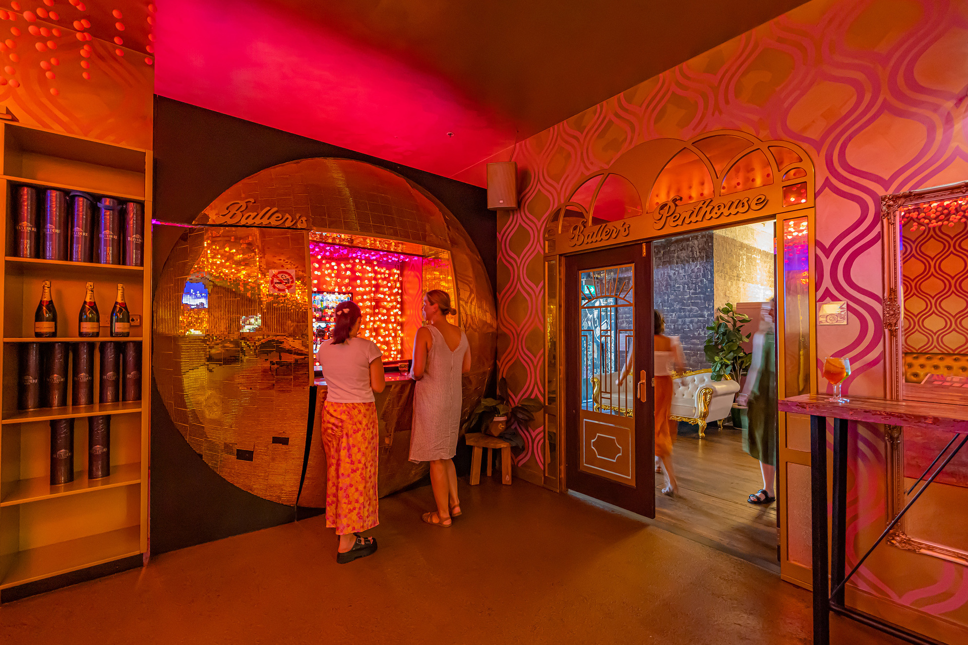Two people are inside a neon lit games arcade 