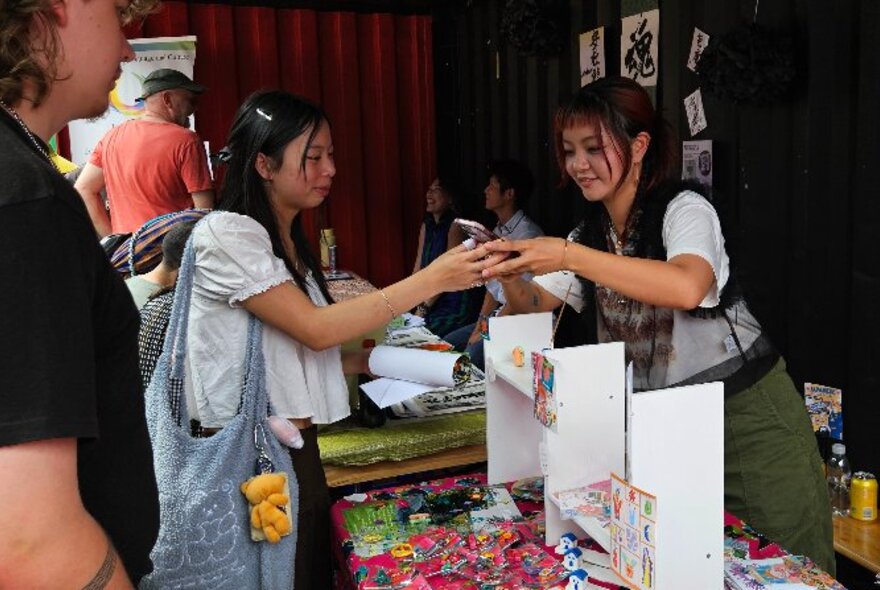Customers purchasing goods from a Japanese market stall.