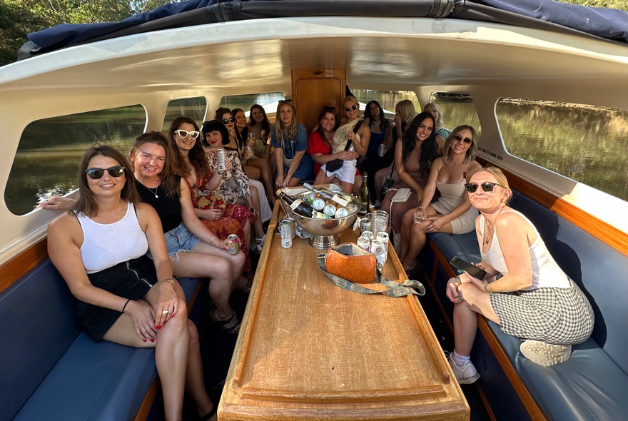 People seated in a water taxi cabin on the Yarra River.