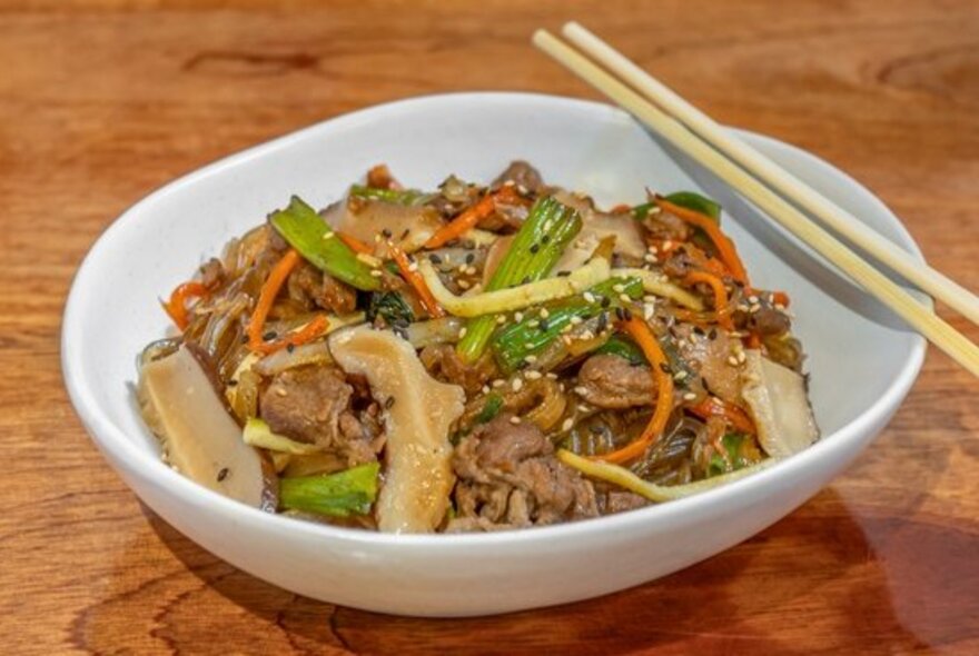 Korean noodles with a set of chopsticks balancing on the bowl. 