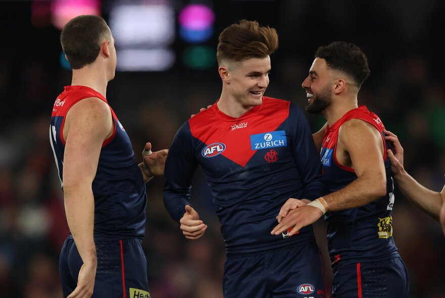 Melbourne AFL football players on the field during a match.