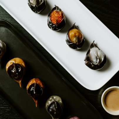 Looking down at two trays of dumplings, one white and one black. 