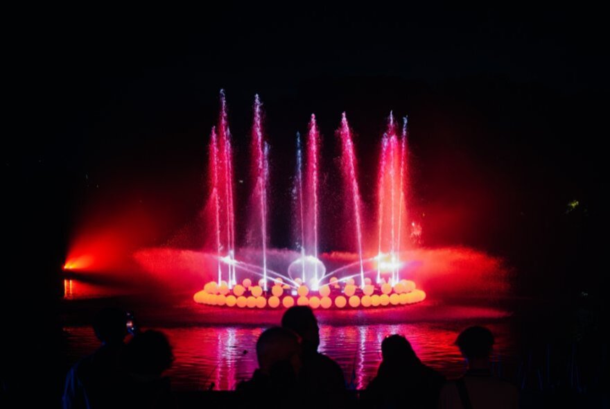 Light installation with red flares and light shapes.