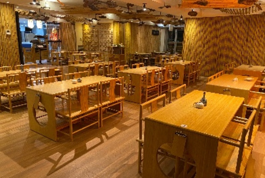 The interior of a restaurant with wooden tables and chairs.