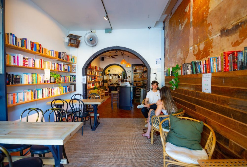 Book-lined walls in a cafe with two people at a small table