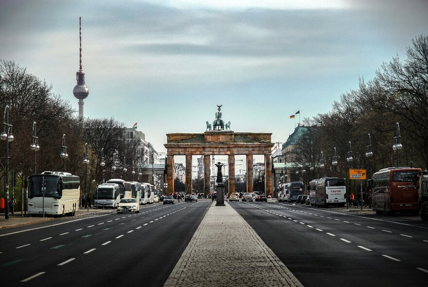 Berlin's Brandenburg Gate road crossing with Berlin Tower and coaches.