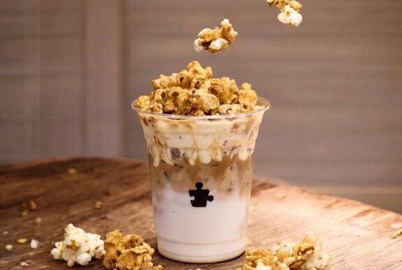 An iced latte with popcorn on top.
