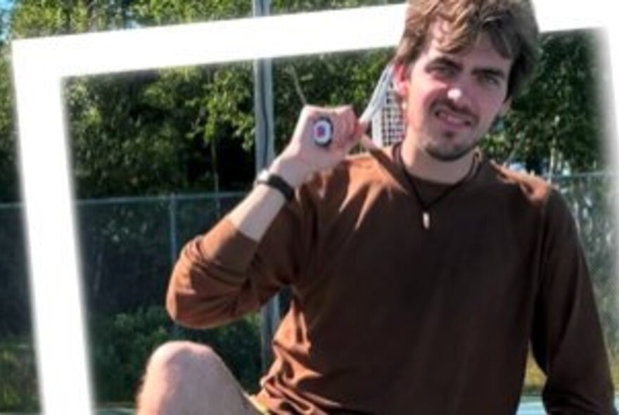 Man holding a tennis racquet next to a white frame
