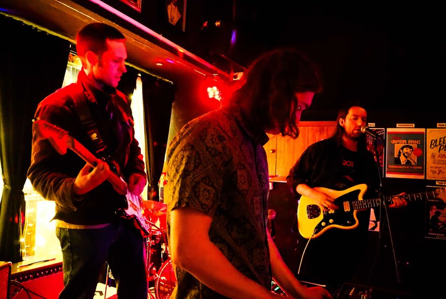 Musicians on stage performing live in a small  venue.