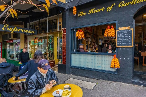 A man is sitting outside a restaurant