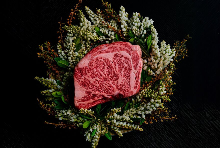 A piece of wagyu steak in the centre of a wreath. 