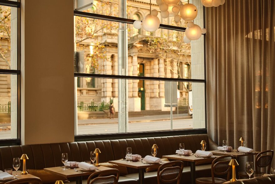 The interior of the restaurant with historic city buildings visible through the large windows. 