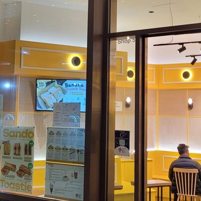 A Hong Kong-style cafe with yellow interiors, seen from outside the shop.