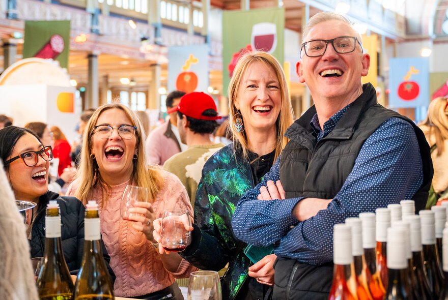 Visitors smiling and enjoying food and drink tastings at The Little Food Market, an artisanal food and wine event held at the Royal Exhibition Building.