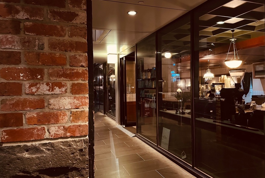 The entrance to Omo cafe, with full length floor to ceiling glass windows.