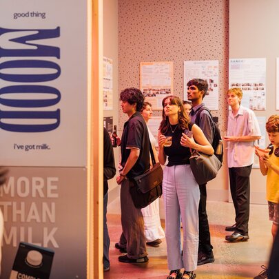 Young people wandering through a gallery exhibition.