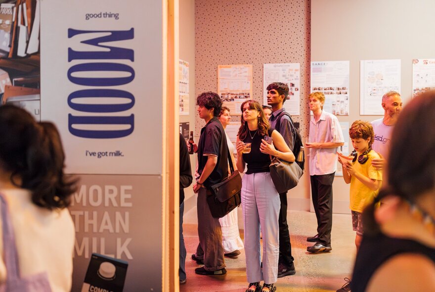 Young people wandering through a gallery exhibition.