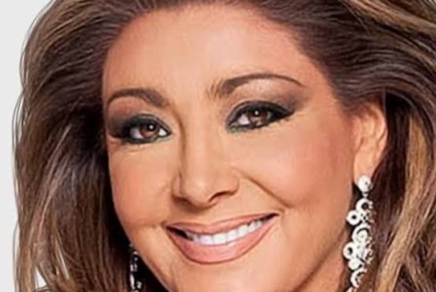 TV personality and lawyer Gina Liano, wearing big flashy earrings, with heavily made up eyes and her hair teased back.