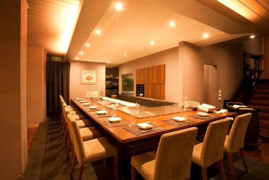 Large dining table with chairs set around a central serving area.