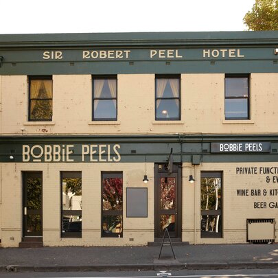 Exterior of Bobbie Peels hotel. situated on a corner, with a cream and dark green exterior.
