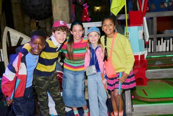 A group of kids posing at mini golf.