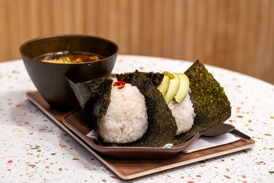 Two Japanese rice balls and miso soup. 