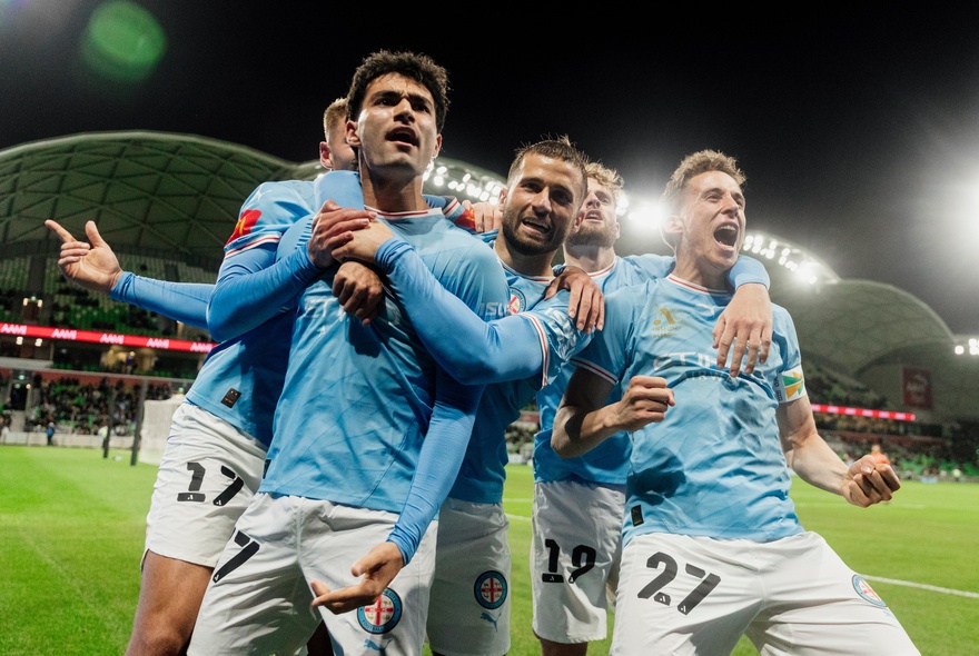 A mens soccer team in pale blue kit in a group on the field during a match.