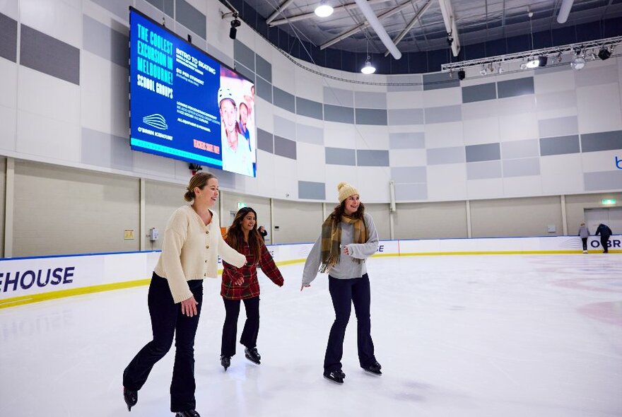 Three friends are ice skating