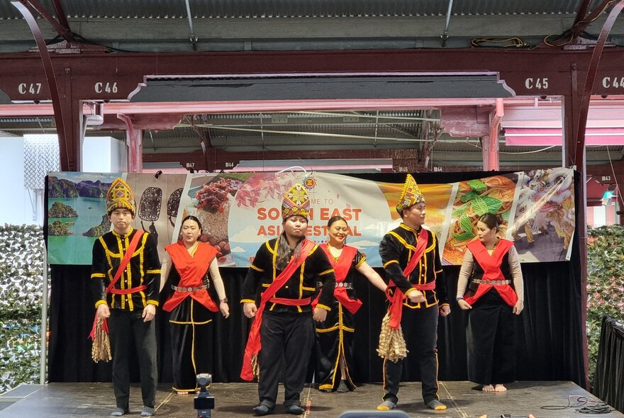 A cultural performance taking place on a small stage as part of the South East Asia Festival, at the Queen Victoria Market.