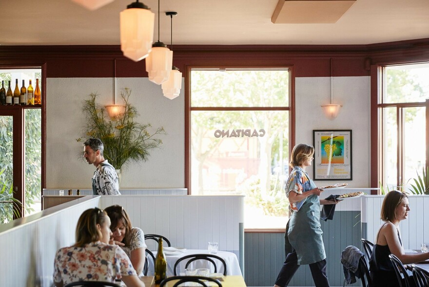 People eating in booths in an Italian restaurant.