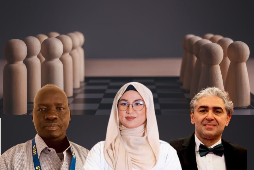 Three people with wooden pegs on a chessboard behind them. 