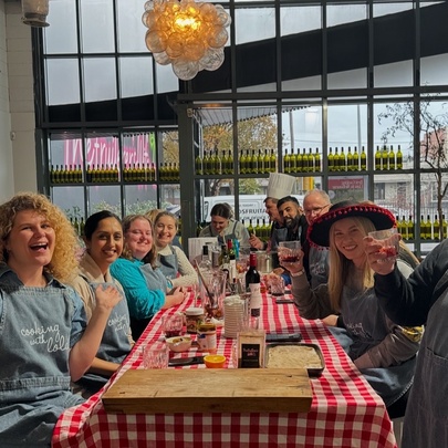 A group of people seated at a long table in a restaurant, smiling.
