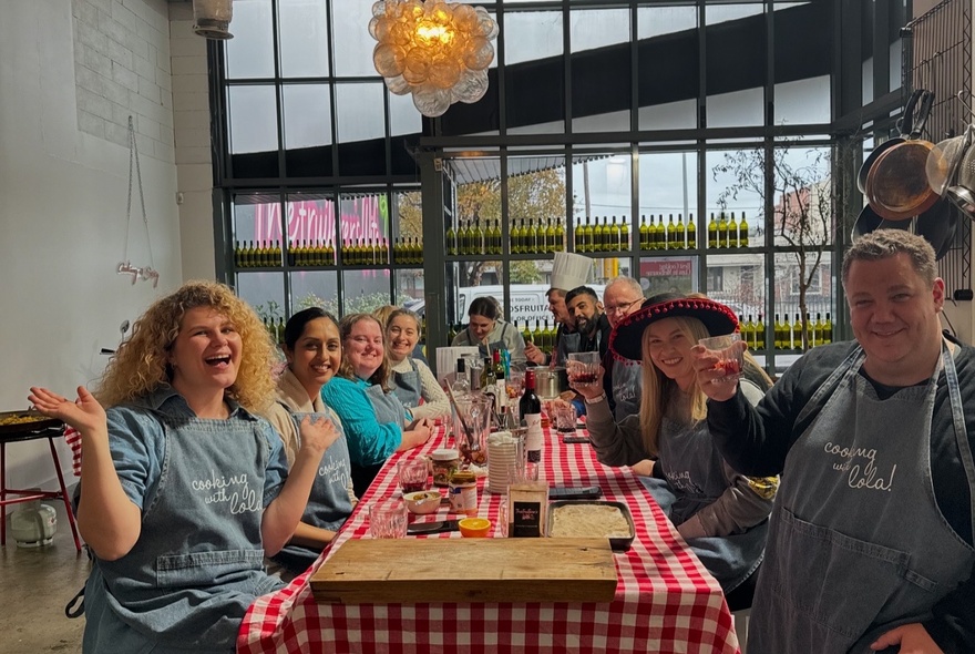 A group of people seated at a long table in a restaurant, smiling.