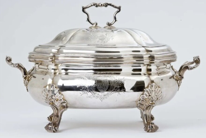 A Georgian silver tureen with legs and handles.