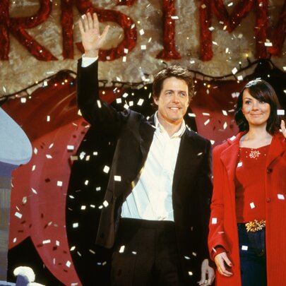 Still from Love Actually, Hugh Grant and Martine McCutcheon waving awkwardly while snow falls.