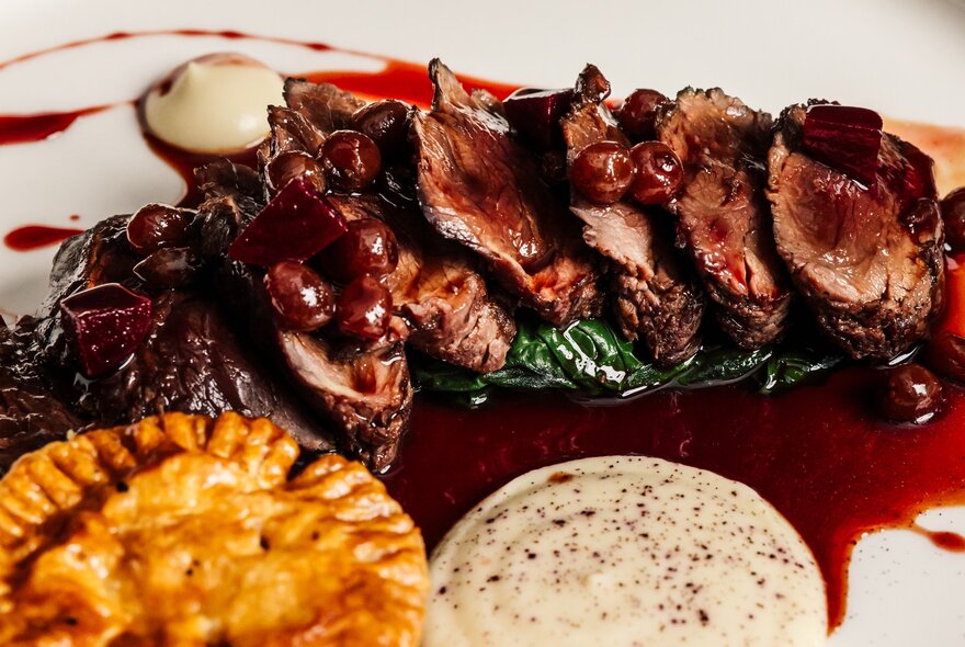 A decadent meat dish with a rich red sauce and a pot pie.