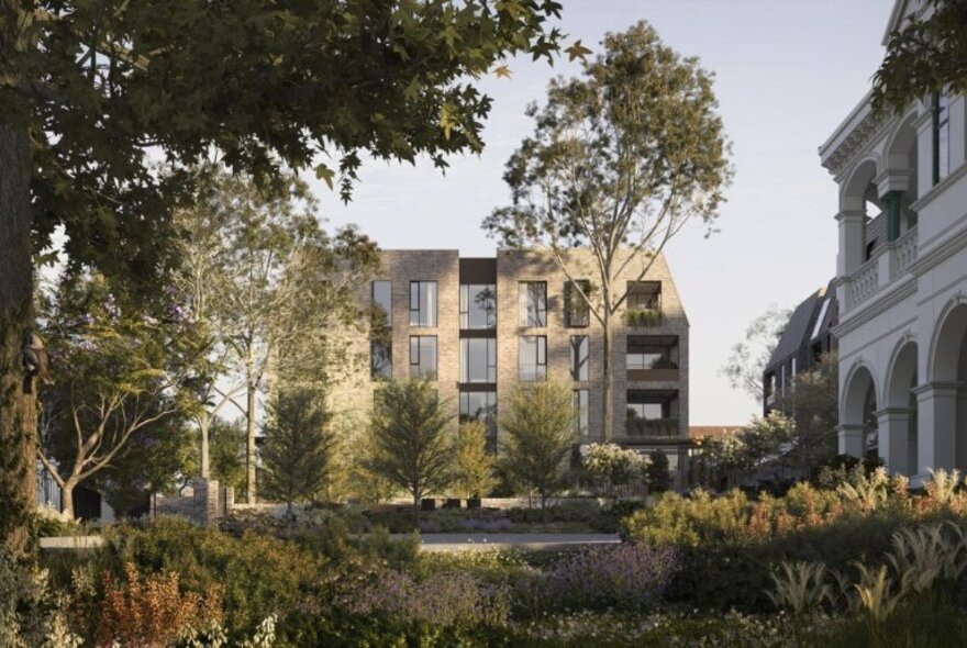 Looking through a landscaped garden to modern low-level apartment blocks. 