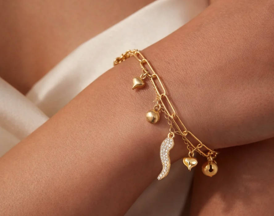 A chain bracelet with diamante cornicello and other gold charms.