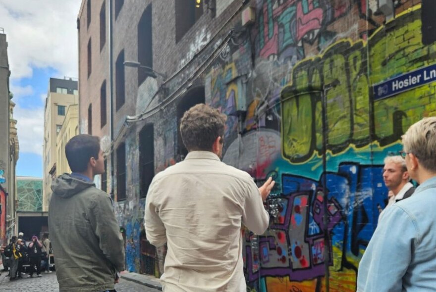 People looking at graffiti in a Melbourne laneway.