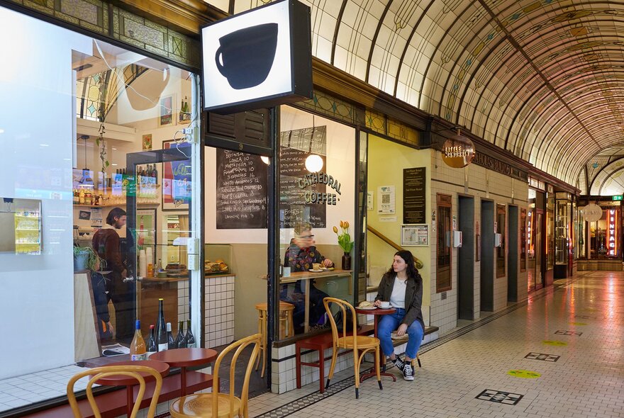 A bar with a giant coffee sign in an ornate arcade.
