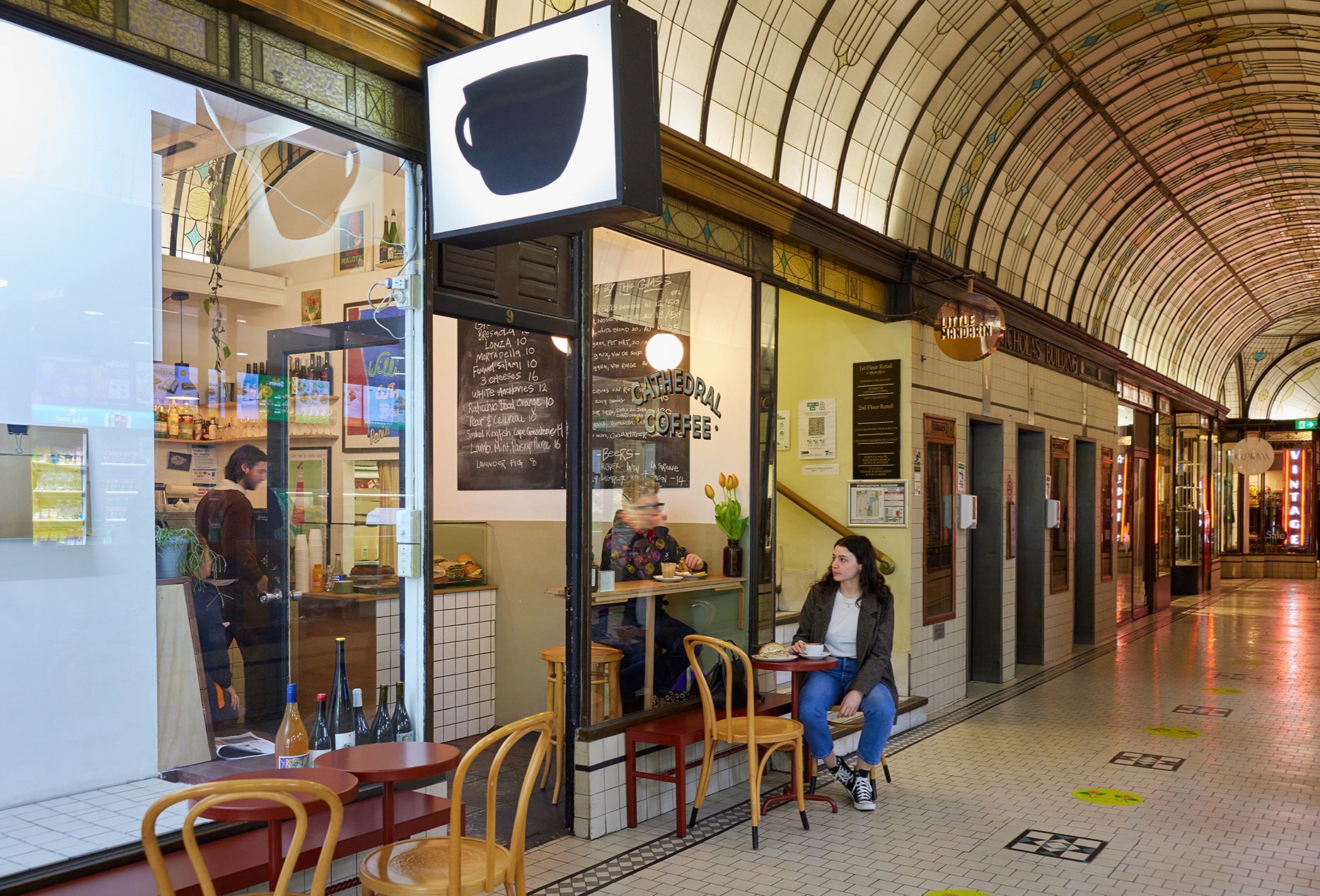 A bar with a giant coffee sign in an ornate arcade.