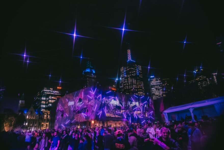 A large crowd enjoying an open air live performance at Melbourne's Fed Square.