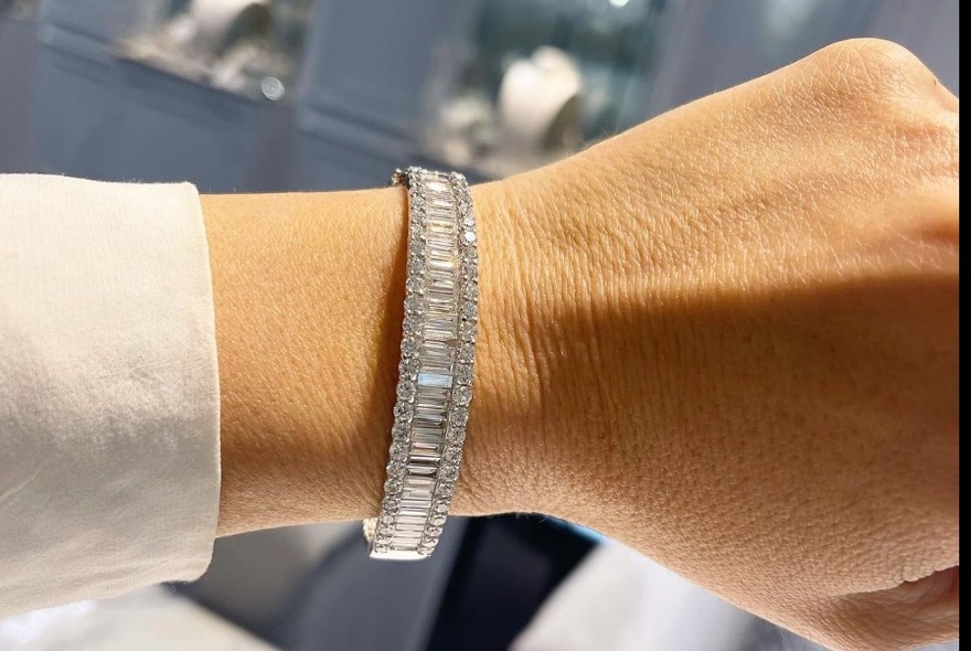 Chunky diamond bangle on wrist, with white shirtsleeve.