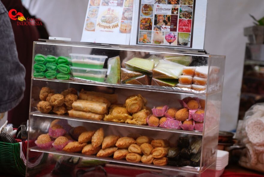 Traditional Indonesian food displayed in a glass display case.