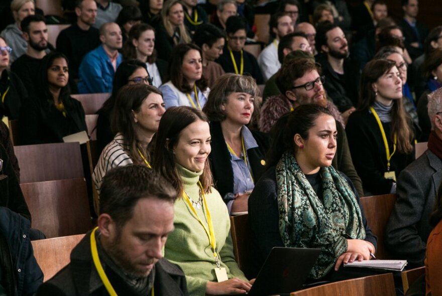 Looking at a seated audience listening to a speaker. 